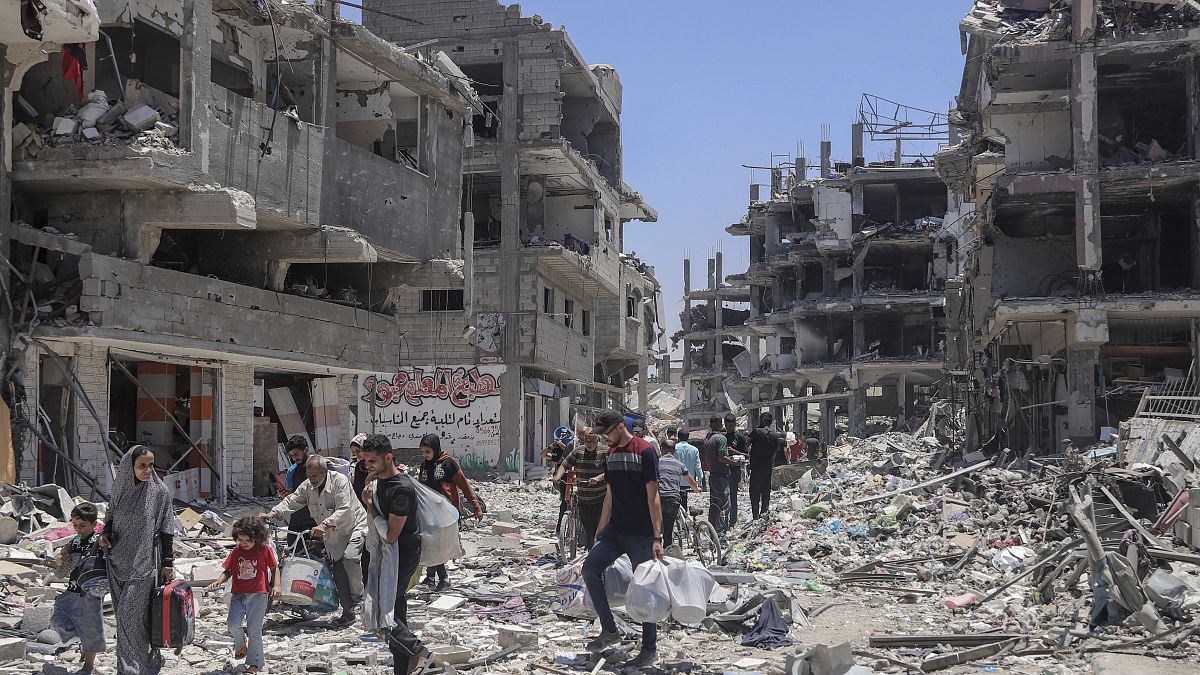 Los habitantes de Gaza buscan sus pertenencias en las ruinas del campo de refugiados de Jabaliya después de la retirada de las FDI